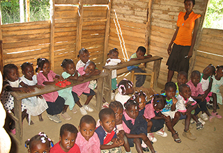 The old Flower of Hope School's classrooms had dirt floors and no chairs for the students.